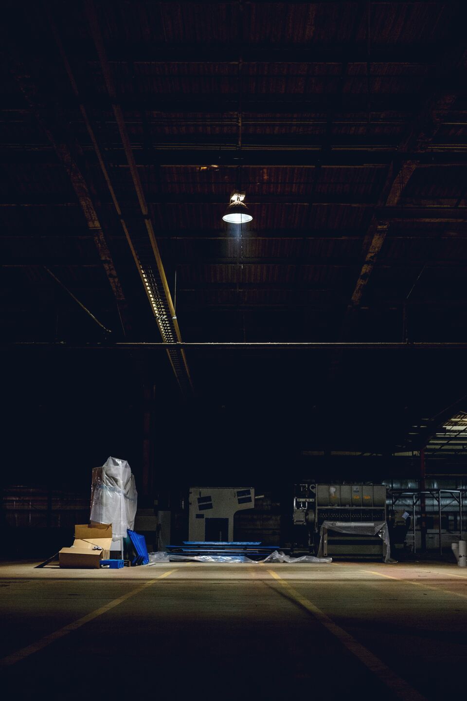 Stacked boxes in a dark warehouse with warm pools of light