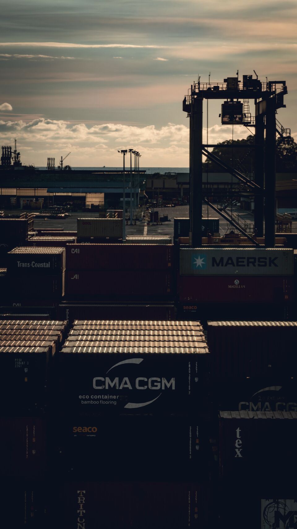 Shipping containers stacked at sunset