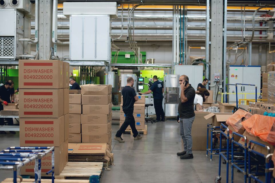 Worker sorting parcels at a packing station