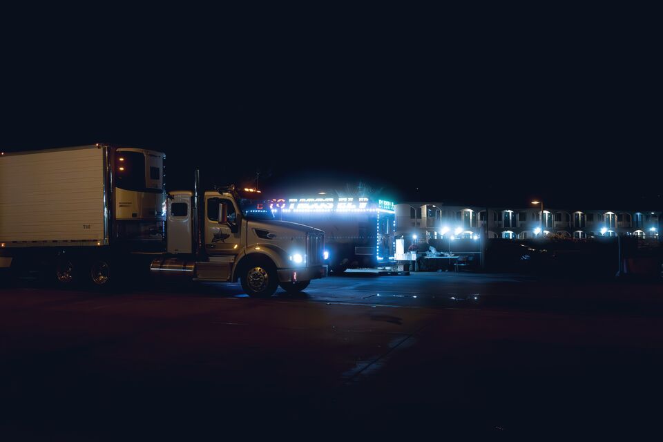 Parked semi truck with amber marker lights at night