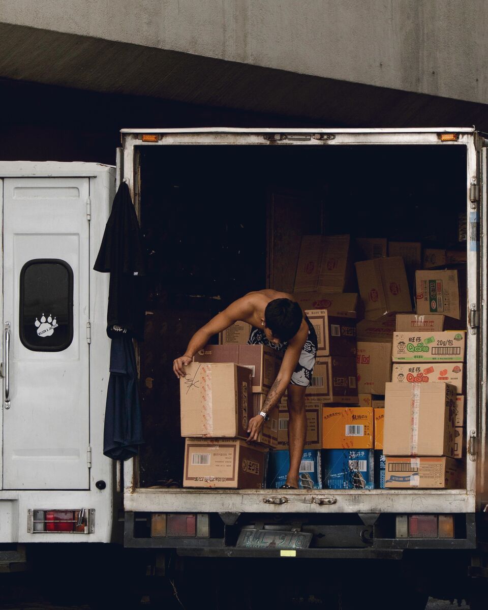 Worker moving cartons inside a loaded trailer